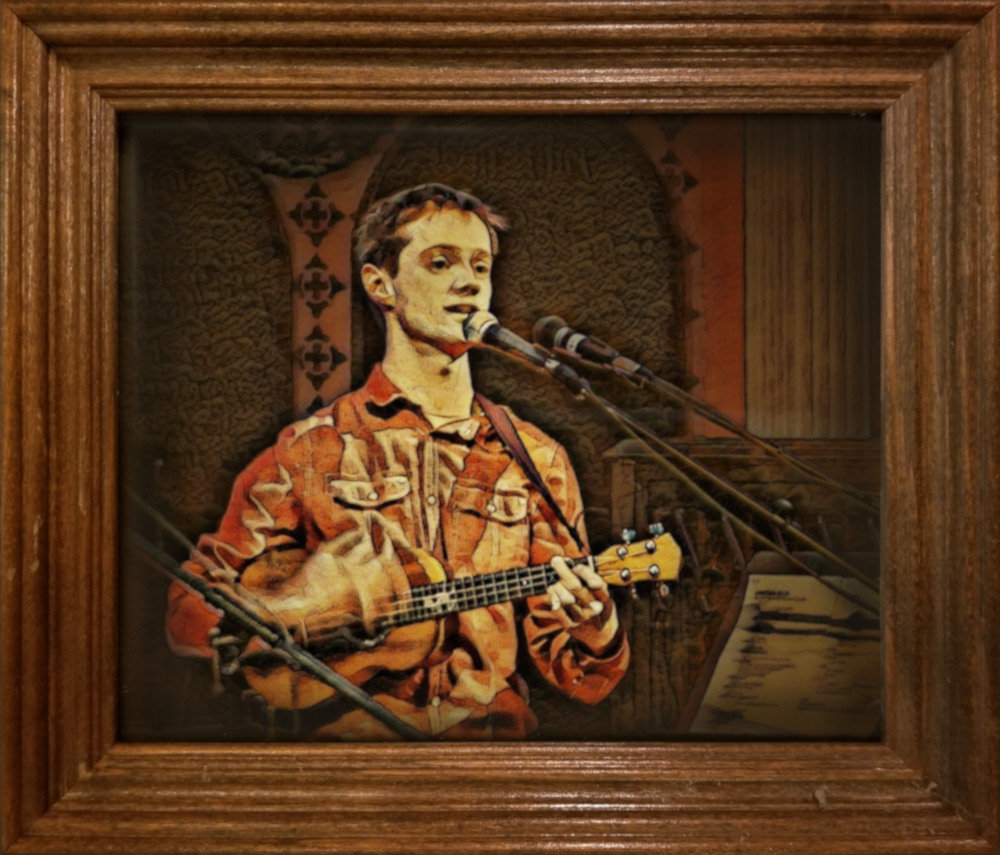 A wooden frame containing a picture of Mark playing ukulele, stylized like a painting